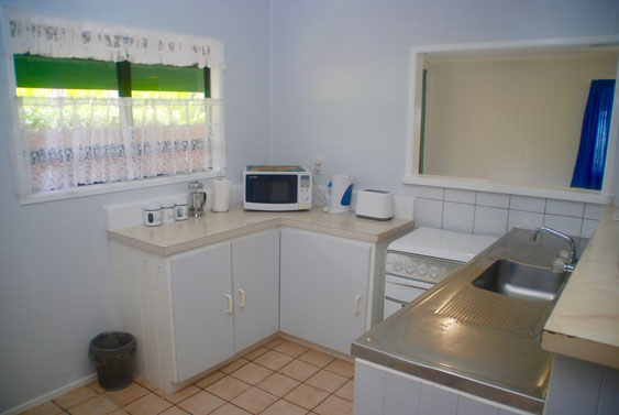 the kitchen there is a full stove, microwave and a fridge freezer